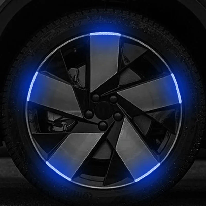 Close-up of a car wheel rim with bright blue reflective strips illuminating the spoke design.