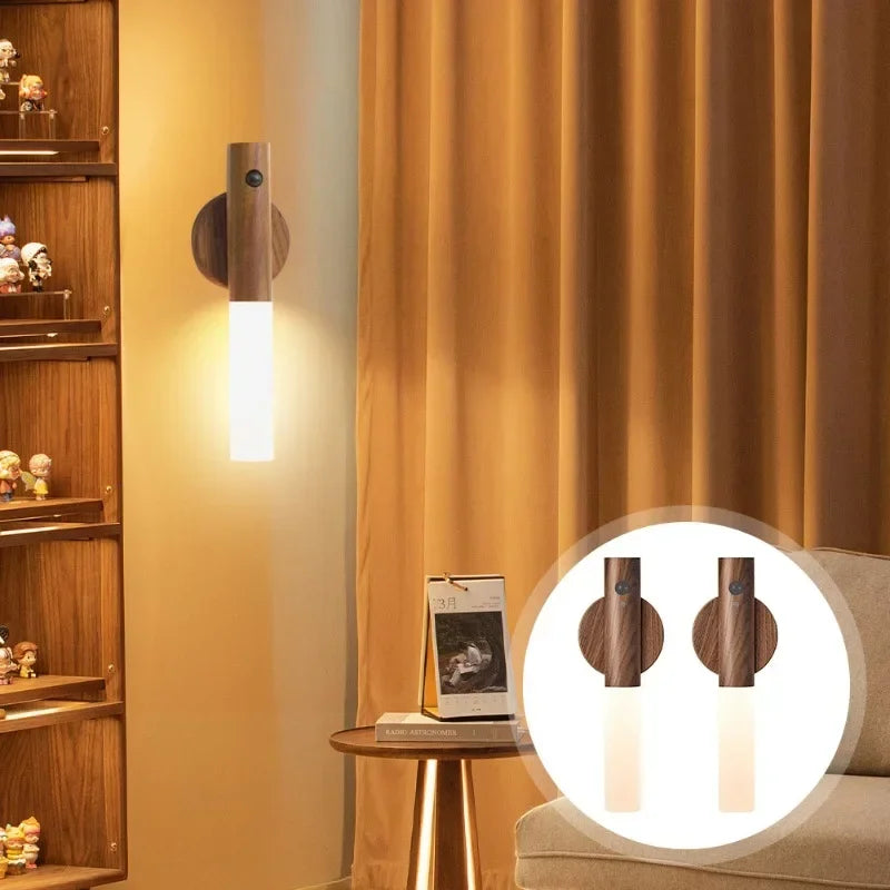 A magnetic LED wall light fixture mounted on a wooden shelf, illuminating a wall with a warm glow.