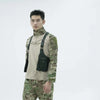 A male model wearing a camouflage shirt and olive green underarm wallet bag with an adjustable strap.