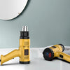 A yellow heat gun is shown on a white surface against a light blue wall, with another similar tool nearby.