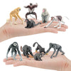 A collection of realistic animal figurines including monkeys, bats, and other wildlife on a person's hand.