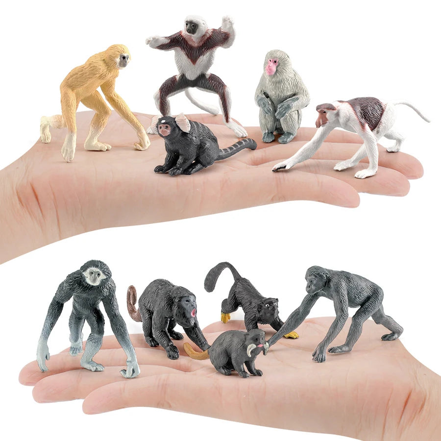 A collection of realistic animal figurines including monkeys, bats, and other wildlife on a person's hand.