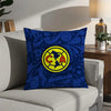 A dark blue decorative pillow featuring a yellow circular logo with the letters CA inside.