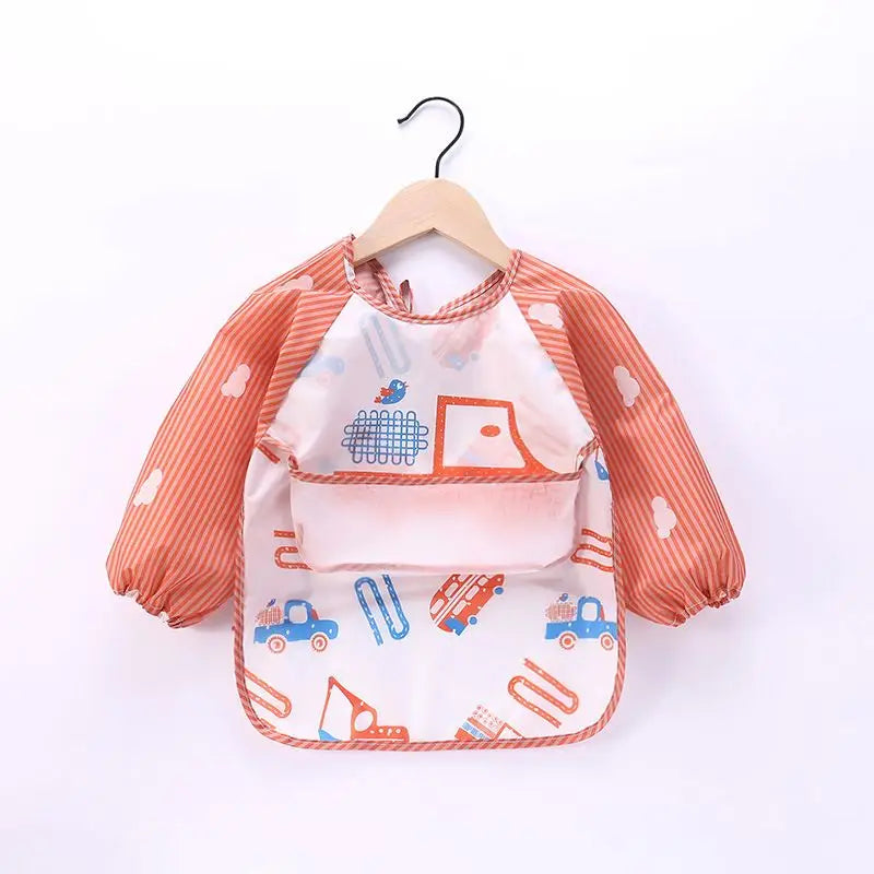 A pink waterproof long-sleeve baby feeding smock with orange stripes and blue accents, hanging on a wooden hanger.