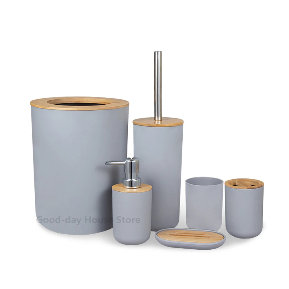 A set of bamboo bathroom organizers including a cylindrical soap dispenser and matching cups.