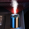 A smart car aroma diffuser is shown emitting a white mist and projecting red laser beams onto a dark surface.