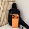 An orange smartphone is placed inside a black water-resistant nylon chest sling bag against a light wall.