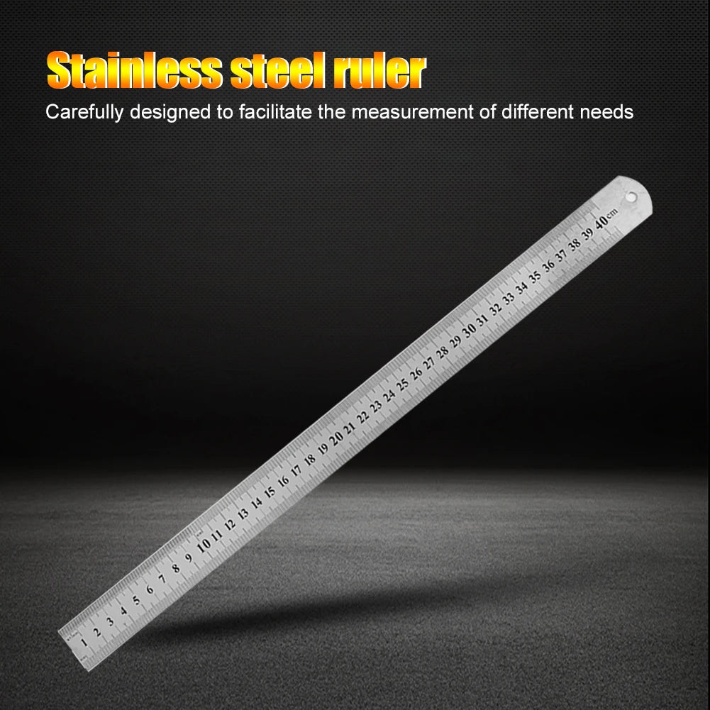 A stainless steel ruler showing markings up to 40 cm, lying diagonally on a dark surface.