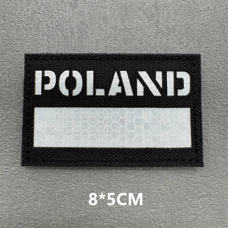 A black rectangular patch with white text reading POLAND on a gray background.