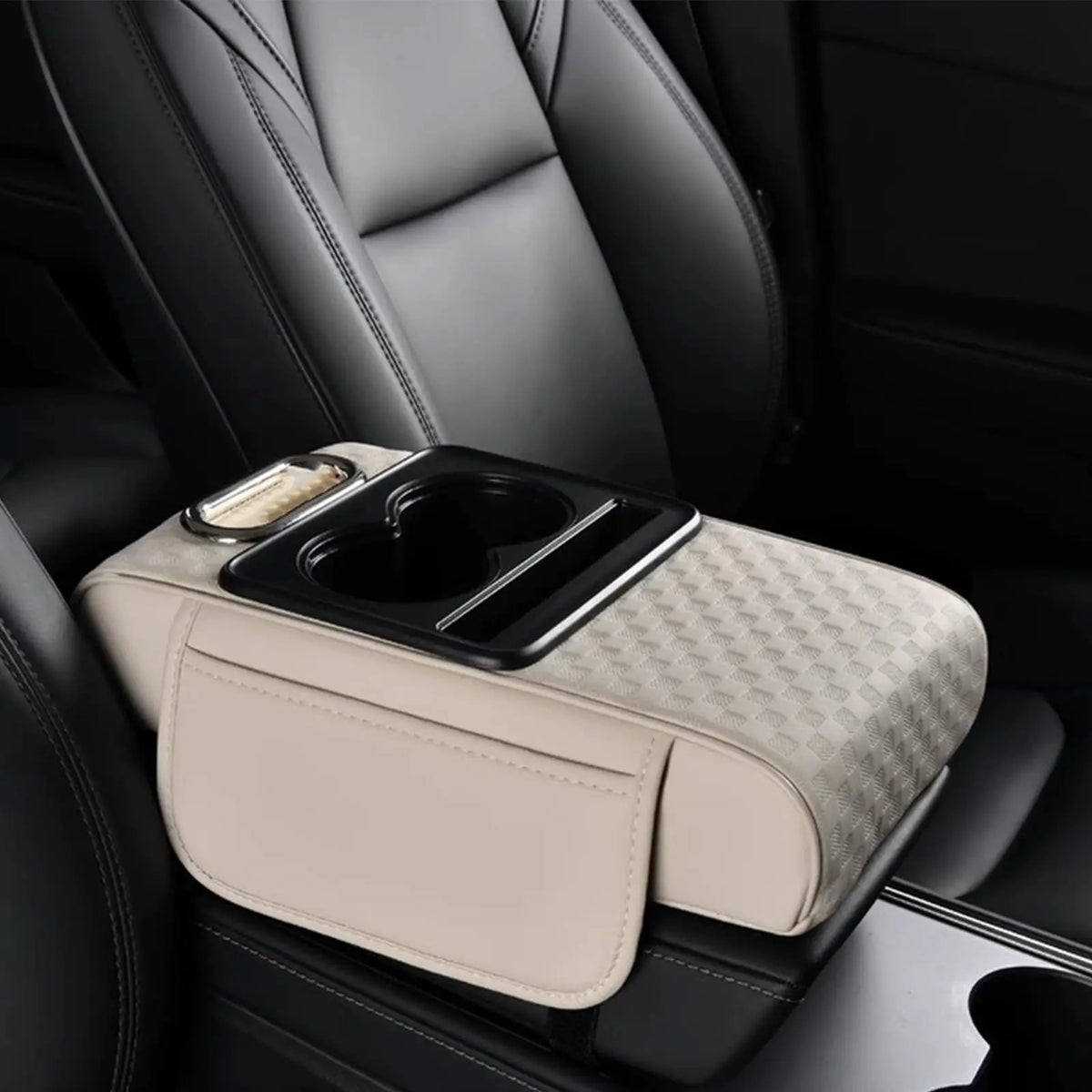 A beige car armrest cushion with a black cupholder and storage compartment is shown in a dark car interior.