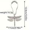 A silver metal dragonfly shower curtain hook with a hanging loop and a decorative body.