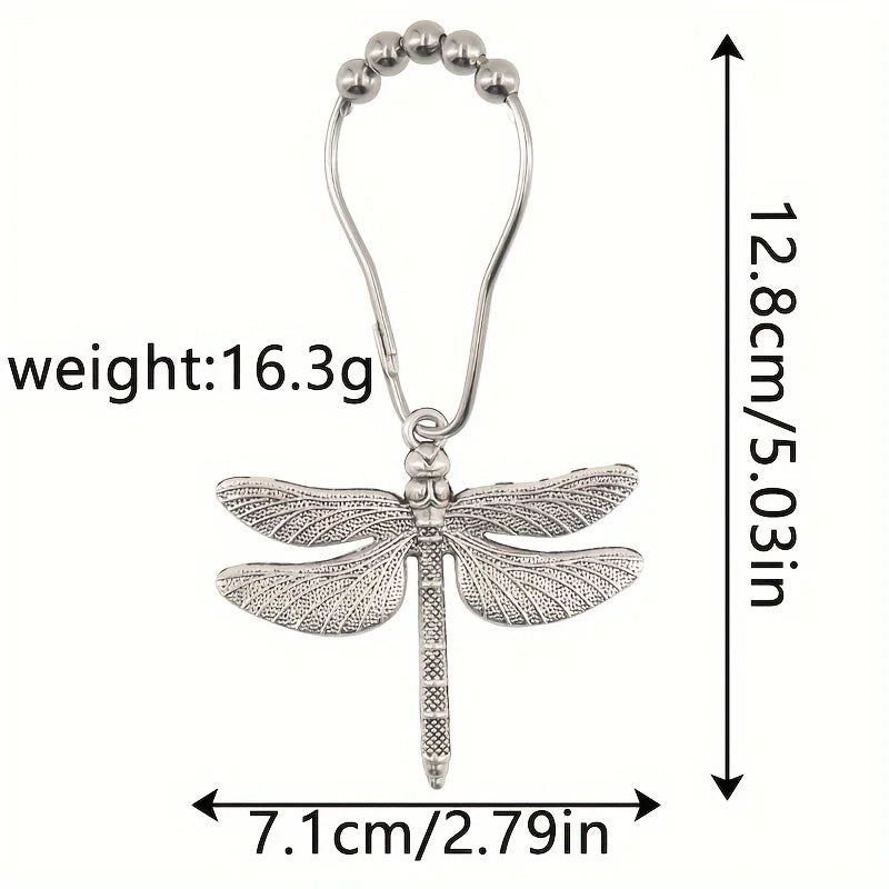 A silver metal dragonfly shower curtain hook with a hanging loop and a decorative body.