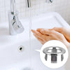 A hand is operating a chrome-plated sink overflow cover set, showing the mechanism for water flow.
