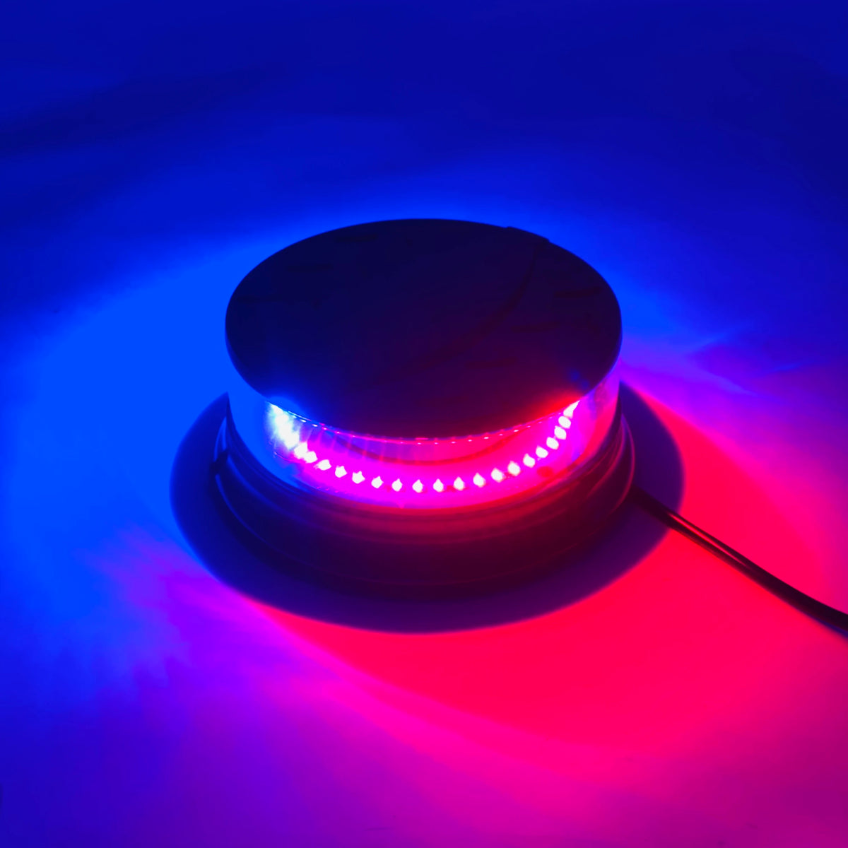 A magnetic mount LED emergency strobe light emitting bright purple and pink light against a blue background.