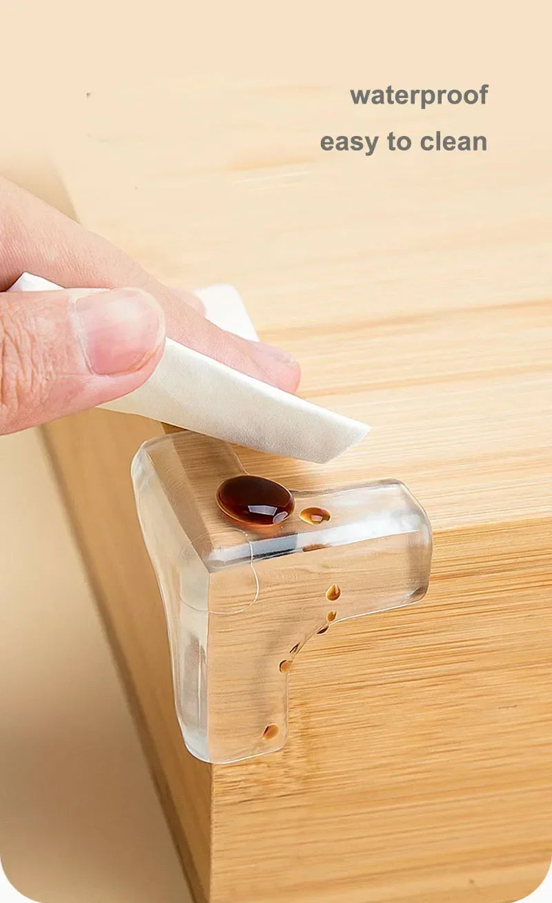 A hand wipes a silicone corner edge guard on a wooden surface, demonstrating its waterproof and easy-to-clean features.