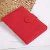 Un porte-passeport en cuir rouge repose sur une surface blanche à côté d'un panier tissé.