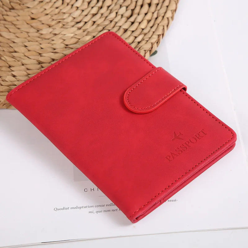Un porte-passeport en cuir rouge repose sur une surface blanche à côté d'un panier tissé.