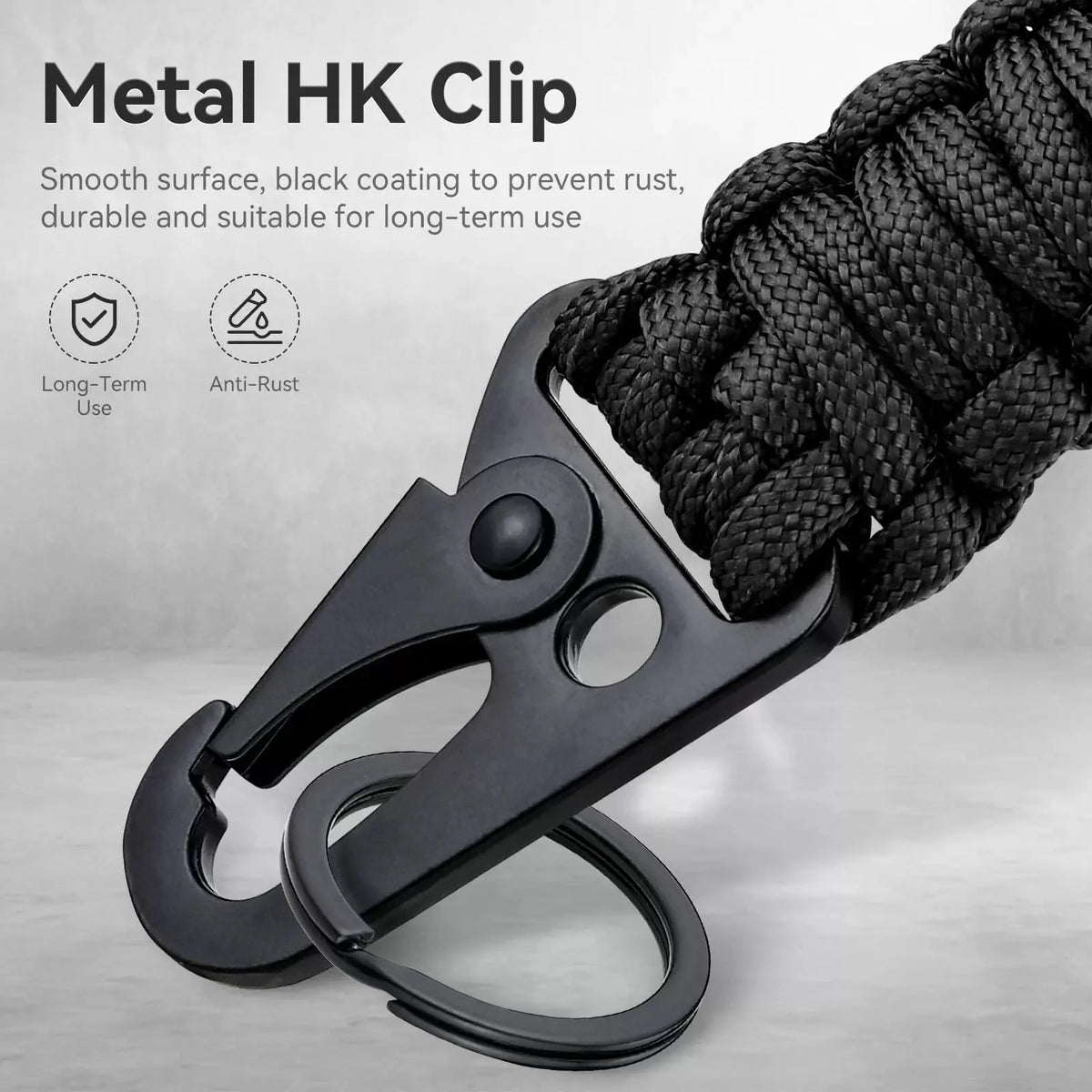 A close-up of a black metal HK clip attached to a thick black paracord rope.