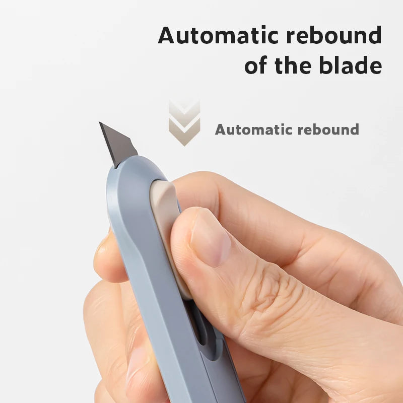 Eine Hand hält einen hellblauen Präzisions-Mini-Papiercutter mit Rückfederfunktion.