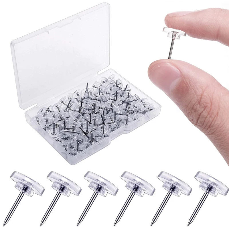 A clear plastic box containing 100 transparent push pins or thumb tacks.