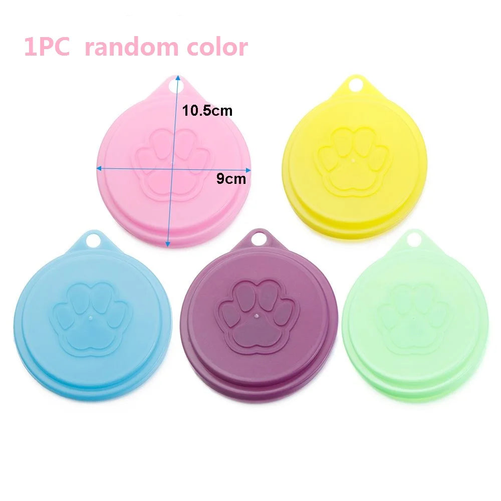Three silicone food storage lids in random colors pink yellow blue and green with paw print designs