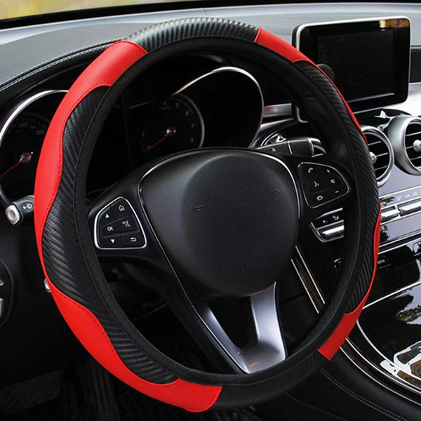 A black steering wheel with a red stitched cover and controls visible inside a car interior.