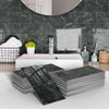 A display of stacked dark green marble self-adhesive wall stickers used as 3D tile decals in a bathroom setting.