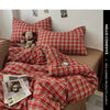 A close-up of a red plaid duvet cover set featuring a classic tartan pattern on a bed.