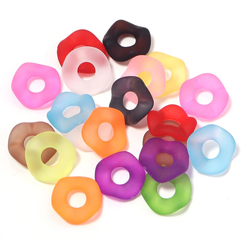 A collection of colorful acrylic spacer beads in various shades including red, pink, yellow, green, and purple.