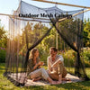A couple relaxing under an outdoor mesh canopy in a grassy garden setting.