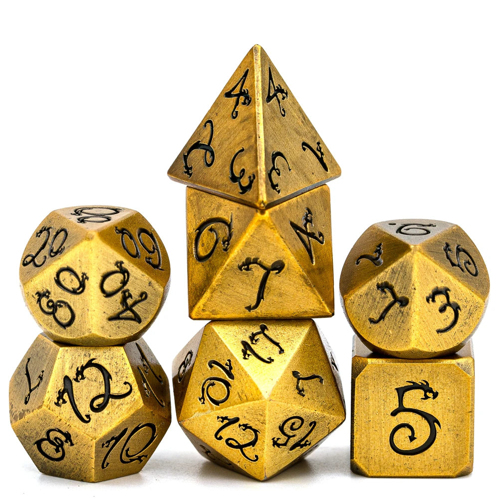 A set of seven gold metal polyhedral dice featuring a dragon font design.