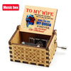 A wooden music box with an engraved lid featuring text and a painted illustration of a couple.