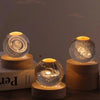 Laser engraved crystal ball night light with a swirling pattern on a wooden base