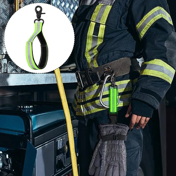 A hand wearing a dark jacket with reflective stripes holds a green clip and a gray glove, demonstrating versatile hanging cli