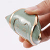 A hand holds a light green TPU smart key fob cover with a gold trim and an etched logo.