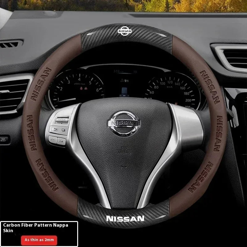 A close-up view of a Nissan steering wheel with a brown carbon fiber patterned grip cover.