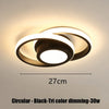 A circular black LED ceiling light fixture with a diffused glow mounted on a wall.