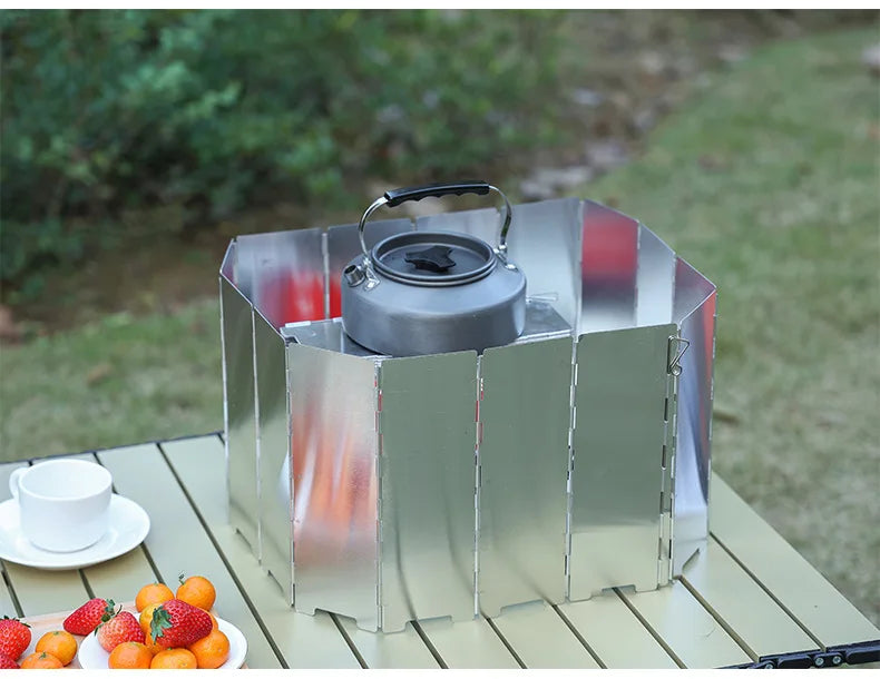 A portable aluminum alloy windshield is displayed on a wooden surface with fresh fruit nearby.