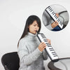 A woman is playing a black 32-key melodica with a case and mouthpieces, shown alongside an inset diagram.