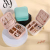 A pink PU leather jewelry storage box with compartments and a teal storage pouch and jewelry displayed.