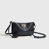 A black classic leather tote bag with a gold metal buckle shown against a light background.