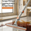 A silver double-sided window cleaning tool with an orange squeegee head is shown cleaning a glass floor.