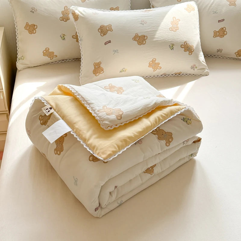 A set of cream and yellow breathable summer duvet covers with a lace trim and bear embroidery.