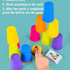 A hand is stacking colorful plastic cups of various sizes and colors, with an activity card visible nearby.