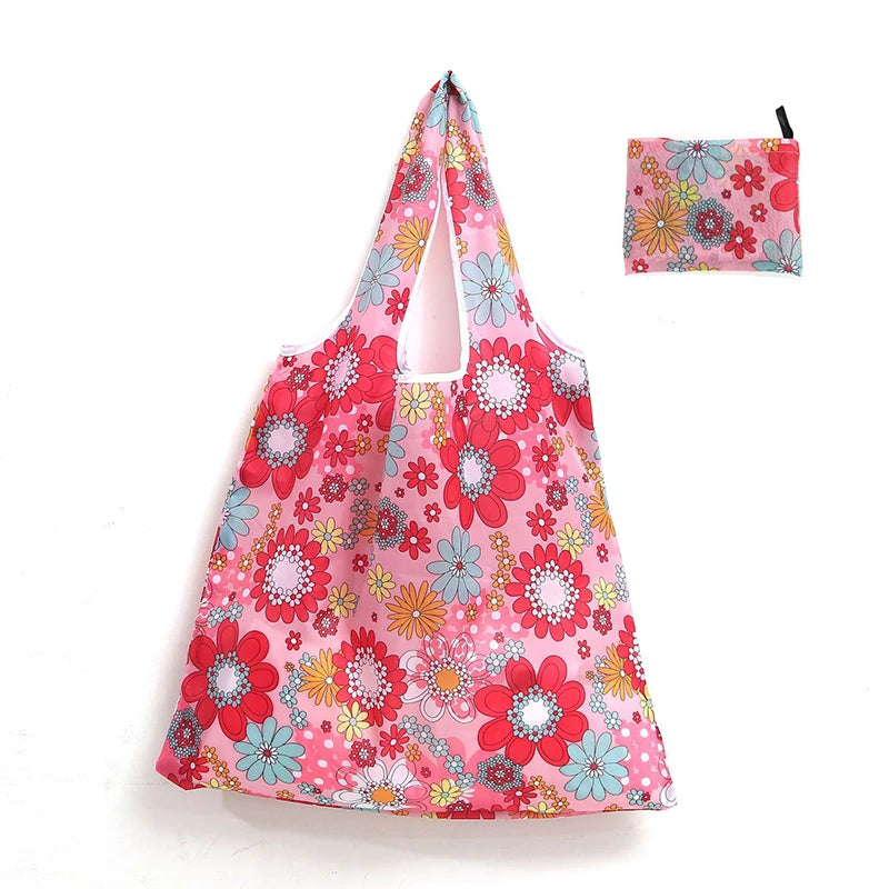 A pink floral reusable shopping tote bag with a matching small pouch.