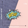 A yellow and blue embroidered lettering patch shaped like WOW on a denim fabric background.