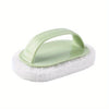 A light green magic sponge scrubber with a long handle resting on a white foam pad.