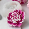 A pink and white heart flower silicone mold for crafting projects is shown next to a white wax mold.