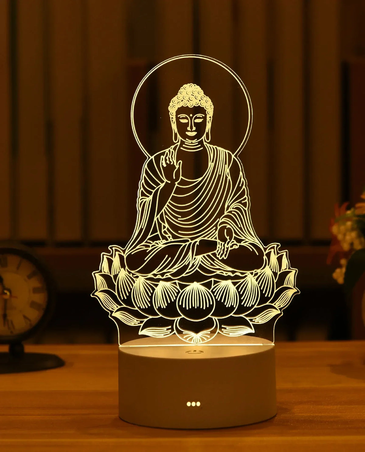 A glowing silhouette of a meditating Buddha in a lotus pose is displayed on a wooden surface.