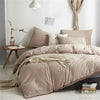 A beige duvet cover set with pom tassels on a bed, featuring soft microfiber bedding.